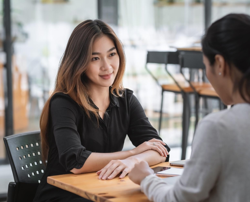 Side view of a woman smiling at coworker