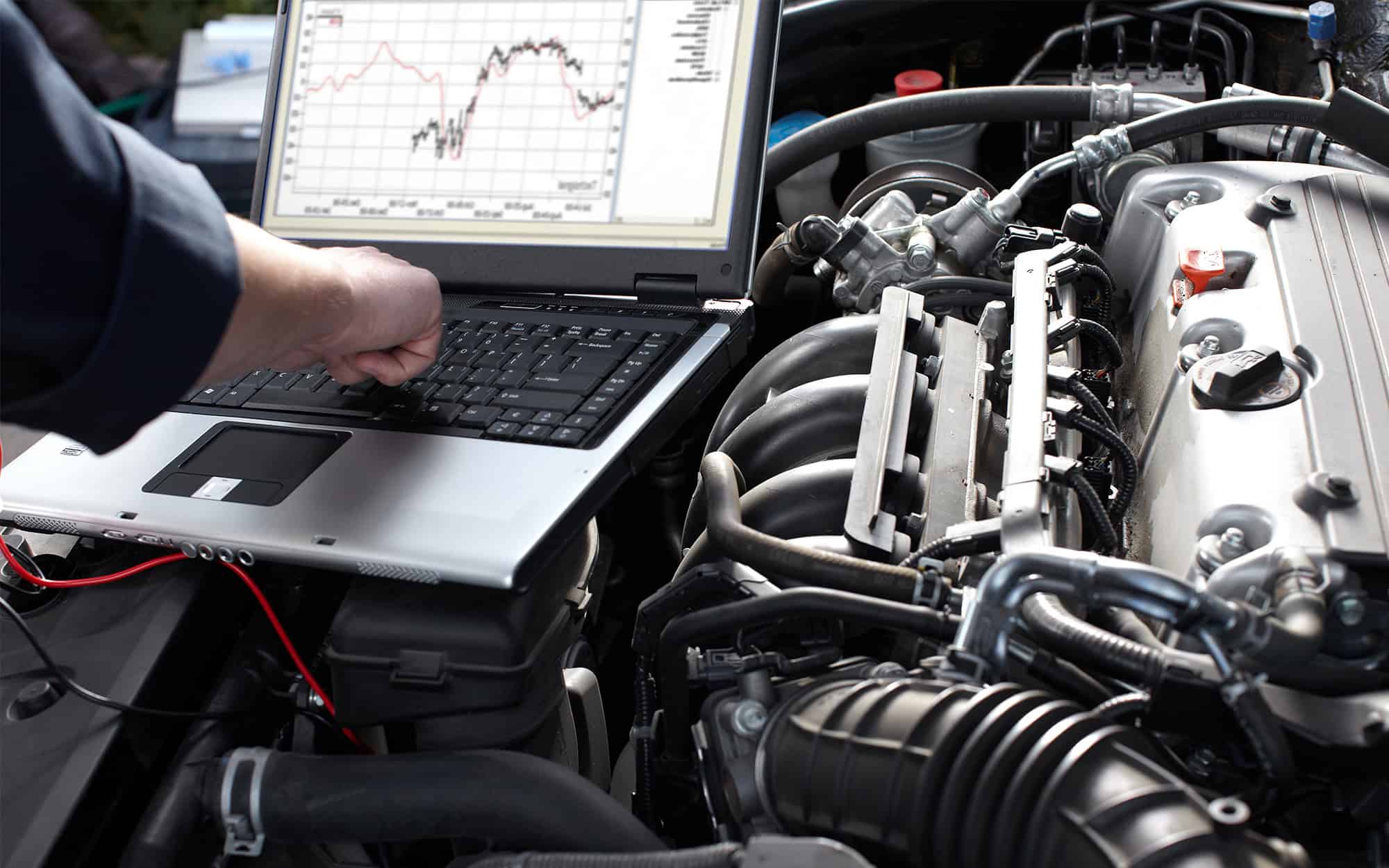 Front view of a mechanic working on the engine of a car