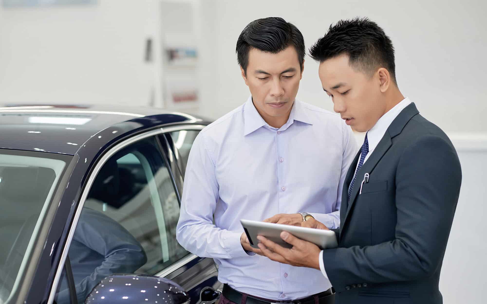 Front view of two car salesmen working