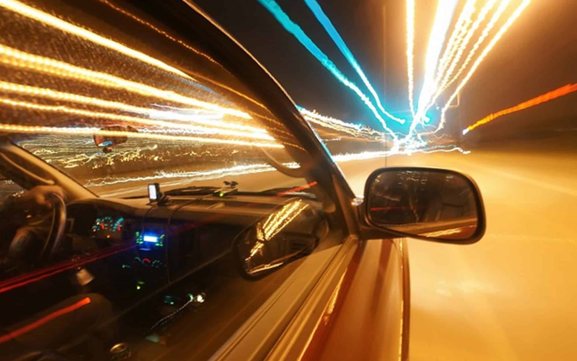 Side view of car going fast focused on side mirror