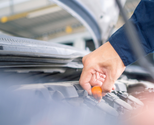 A close up of the hand auto mechanic repair engine in a car repair shop