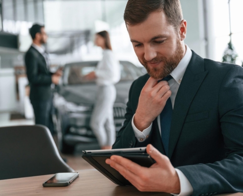 Car salesman looking at data on tablet