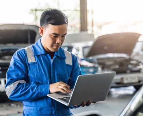 worker in body shop using laptop