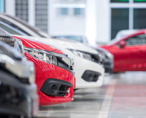 Front view of new cars parked in industrial plants ready to be sold to dealers