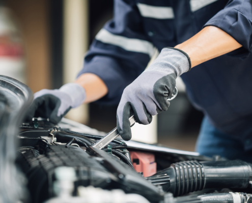 Mechanic works on the engine of the car in the garage