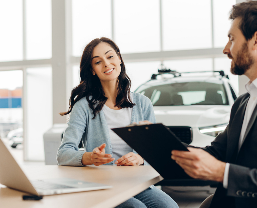 Car salesman showing contract to customer in dealership