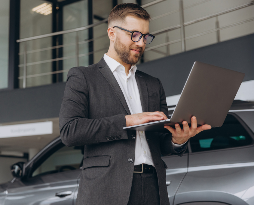 Modern bearded man in glasses and suit vehicle sales consultant